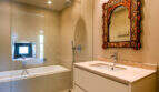 Elegantes Badezimmer mit Badewanne, Regendusche und verziertem marokkanischem Spiegel in Finca Esporles