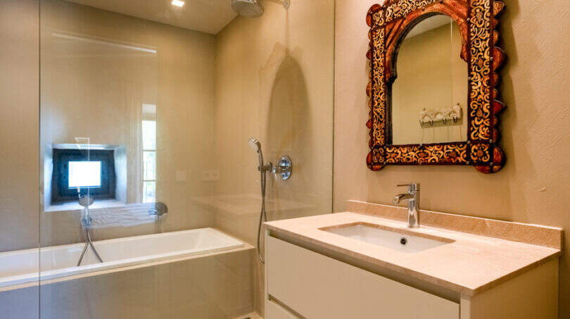 Elegantes Badezimmer mit Badewanne, Regendusche und verziertem marokkanischem Spiegel in Finca Esporles