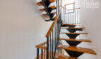Moderne Treppe mit Holzstufen und schwarzem Metallgeländer im Eckreihenhaus Ses Salines