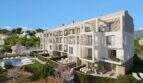 External view of new construction Palmanova: modern residential building with balconies, communal pool and well-maintained garden.