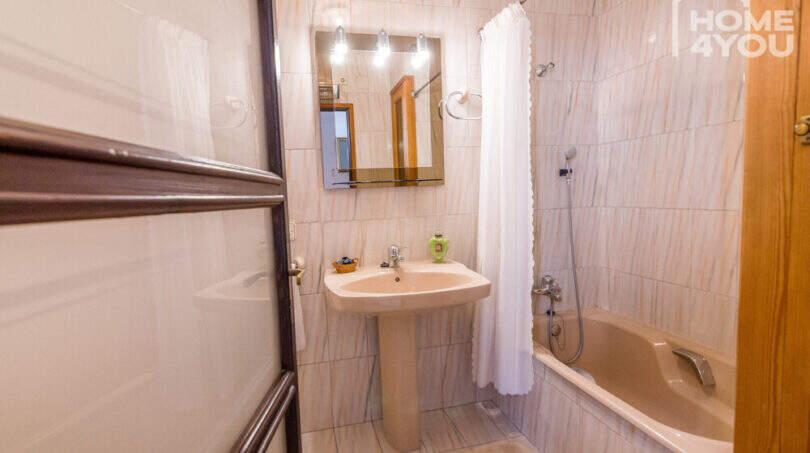 Badezimmer mit Badewanne, Dusche, Waschbecken und Spiegel im historischen Herrenhaus in Porreres.