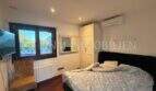 Helles Schlafzimmer der Gästewohnung in Villa Marratxí mit Doppelbett, Klimaanlage und Fenster zum Garten.