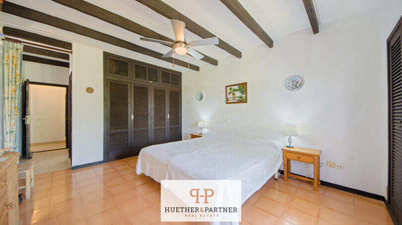 Helles Schlafzimmer mit Doppelbett, Holzbalkendecke, Deckenventilator und Einbauschrank in Cala d'Or