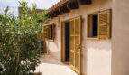 Mediterranes Landhaus mit goldenen Holzläden, Terrakotta-Dach und Innenhof des Agroturismo bei Ses Salines