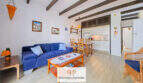 Wohnzimmer mit blauem Sofa, Holzbalkendecke und offener Küche in Terrassen-Wohnung, Cala d'Or