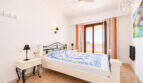 Helles Schlafzimmer mit Doppelbett, Balkon mit Meerblick, Deckenventilator und mediterranem Flair in Ses Salines.
