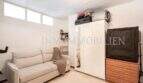 Dormitorio luminoso del apartamento en Port Adriano con sofá, armario blanco y cómoda
