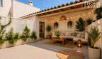 Mediterraner Patio des Herrenhauses in Porreres mit Loungebereich, Holzmöbeln, Lichterketten und üppigen Pflanzen