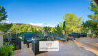 Geräumige Terrasse der Finca in Son Macià mit Loungemöbeln und Sonnenliegen, umgeben von grüner Natur.