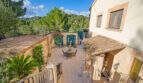 Mediterraner Innenhof der Finca Son Macià mit Terrassenmöbeln, Arkadenbogen und üppigem Grün