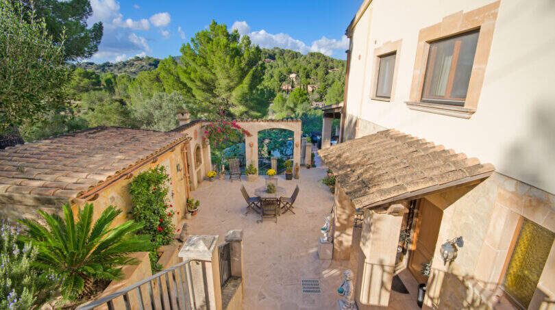 Mediterraner Innenhof der Finca Son Macià mit Terrassenmöbeln, Arkadenbogen und üppigem Grün