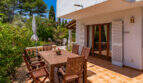 Sonnenterrasse mit Holzmöbeln und Gartenblick am Erdgeschossapartment in Cala Murada