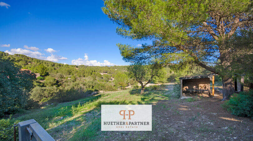 Weitläufiges Grundstück der Finca in Son Macià mit überdachtem Essbereich und Blick in die Natur.