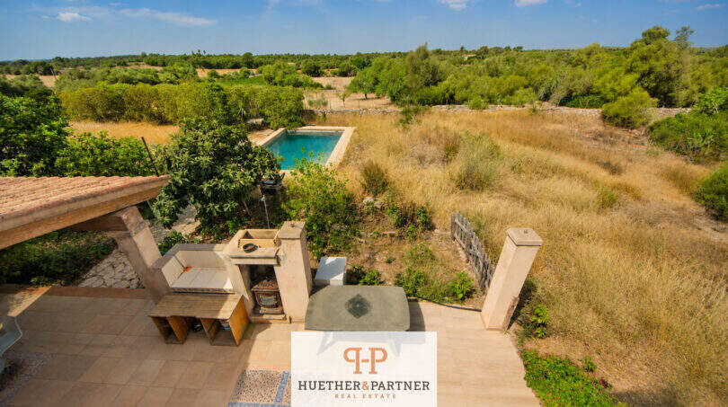 Luftblick auf Terrasse mit Lounge, Pool und weitläufigem Naturgrundstück der Finca bei Felanitx
