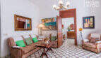 Wohnzimmer des historischen Herrenhauses in Porreres mit Originalfliesen, Kronleuchter, Gemälden und klassischen Sitzmöbeln.