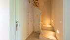 Heller Eingangsbereich mit Treppe, eingebetteten Stufenlichtern und mintfarbenen Einbauschränken in mallorquinischer Finca.
