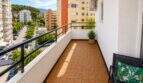 Sonniger Balkon mit Holzfliesen und Stadtblick auf Cala Major, Palma de Mallorca