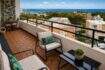Sonnige Dachterrasse des Penthouses in Cala Major mit Holzdielen, modernen Loungemöbeln und Panoramablick auf Meer und Palma