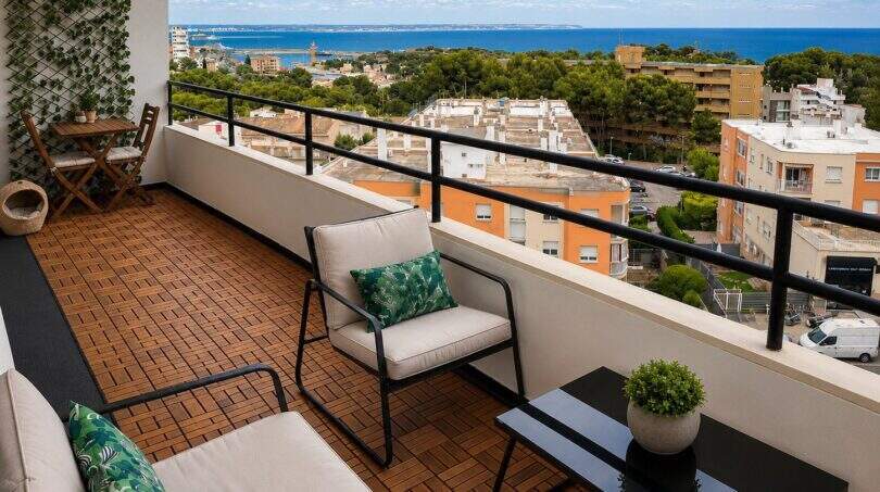 Sonnige Dachterrasse des Penthouses in Cala Major mit Holzdielen, modernen Loungemöbeln und Panoramablick auf Meer und Palma