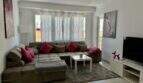 Helles Wohnzimmer mit großem Ecksofa, rosa Kissen, Flachbild-TV und Zugang zum Balkon in Strandnähe, Palma de Mallorca