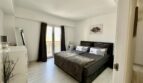 Modernes Schlafzimmer mit Doppelbett, dunklen Vorhängen und Balkonzugang in strandnaher Wohnung in Palma
