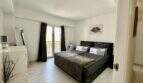 Helles Schlafzimmer mit Doppelbett, dunklen Vorhängen und Balkonzugang in strandnaher Wohnung Palma de Mallorca