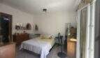 Helles Schlafzimmer der Wohnung in Inca mit Doppelbett, Holzmöbeln, Spiegel und Zugang zum Balkon.