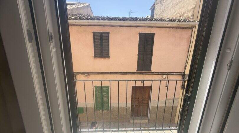 Balkon mit Metallgeländer, Blick auf mediterrane Altstadt-Fassade in Inca, typisch mallorquinische Architektur