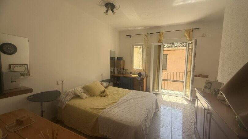 Helles Schlafzimmer der Wohnung in Inca mit Doppelbett, Fliesenboden und Balkon mit Außenblick.