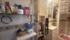 Kleines Badezimmer mit Waschbecken, Dusche, Wandregalen und Stauraum in charmanter Wohnung in Inca.