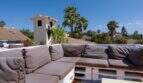 Dachterrasse mit grauer Lounge-Sofa-Gruppe aus Paletten, Meerblick und Palmen in Llucmajor