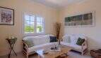Helles Wohnzimmer mit weißen Rattansofas, Holztisch und mediterranem Flair im Bungalow Llucmajor