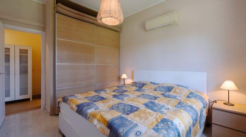 Helles Schlafzimmer mit Doppelbett, Einbauschrank, Klimaanlage und Pendelleuchte im mediterranen Bungalow Llucmajor.