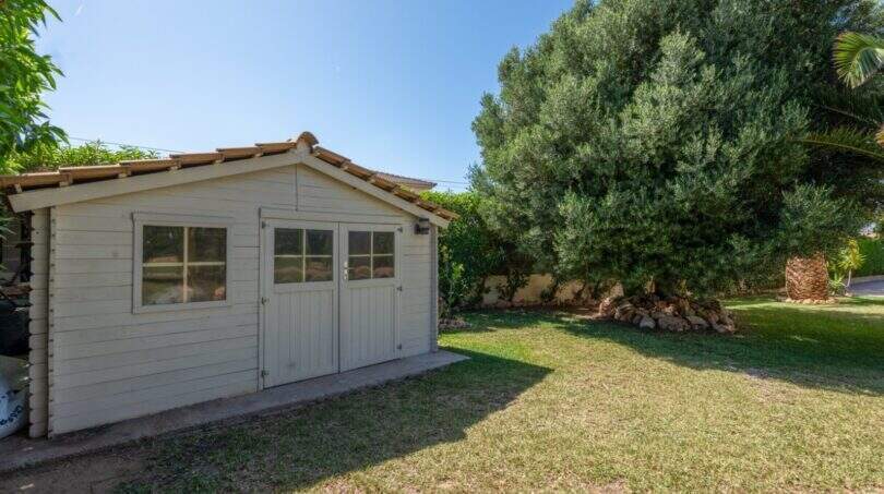Weißes Holzgartenhaus mit Doppeltür im gepflegten Garten des mediterranen Bungalows in Llucmajor