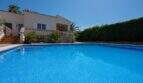 Großer blauer Pool vor mediterranem Bungalow mit Balustrade und Palmen in Llucmajor