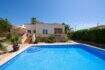 Mediterraner Bungalow in Llucmajor mit großem Swimmingpool, Terrasse und Palmen unter blauem Himmel.