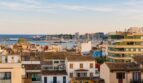 Panoramablick über die Dächer von Palma de Mallorca mit Hafen und Mittelmeer im Hintergrund.