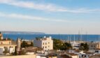 Panoramablick vom Penthouse über Palmas Dächer auf den Hafen mit Segelbooten und das blaue Mittelmeer.