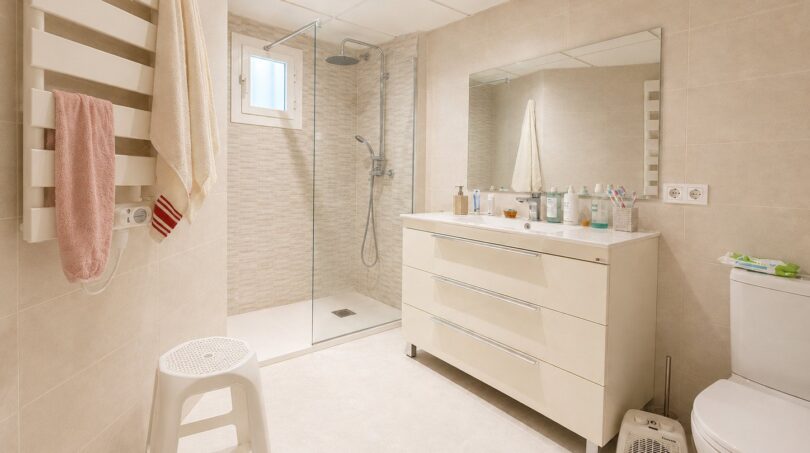 Helles Badezimmer des Penthouses in Palma mit Dusche, Waschtischunterschrank und Handtuchheizung.