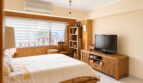 Helles Schlafzimmer mit Bambusbett, TV-Kommode, Klimaanlage und Fenster mit Stadtblick über Palma