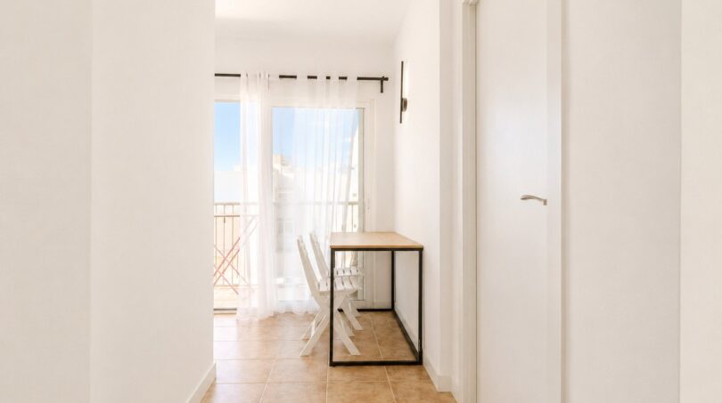 Heller Flur mit Esstisch, weißen Stühlen und Balkonzugang im Penthouse Palma de Mallorca