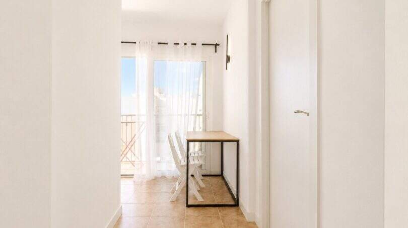 Heller Flur mit Konsolentisch, weißen Stühlen und Balkonzugang im Penthouse Palma de Mallorca
