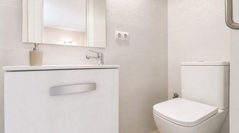 Modernes weißes Gäste-WC mit schwebendem Waschtisch, Spiegel und wandhängendem WC im Penthouse Palma
