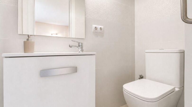 Modernes weißes Gäste-WC im Penthouse mit Waschtischunterschrank, Spiegel und wandhängendem WC.