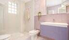 Modernes Badezimmer im Penthouse Palma mit Dusche, Bidet, lila Waschtisch und rosa Wandfliesen.