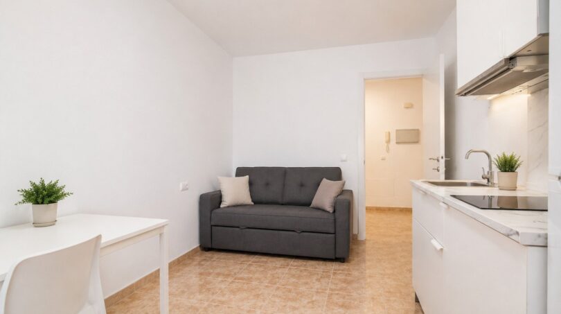 Helles Studio-Apartment mit grauem Sofa, weißer Einbauküche und Esstisch in Palma de Mallorca