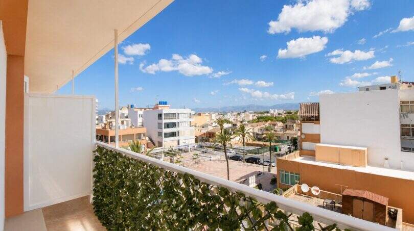 Penthouse-Balkon in Palma de Mallorca mit Grünpflanzenzaun und Panoramablick auf die Stadt und Berge.