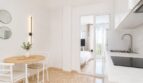 Helles Wohn-Kochbereich mit Esstisch, moderner Küche und Glastür zum Schlafzimmer im Penthouse Palma