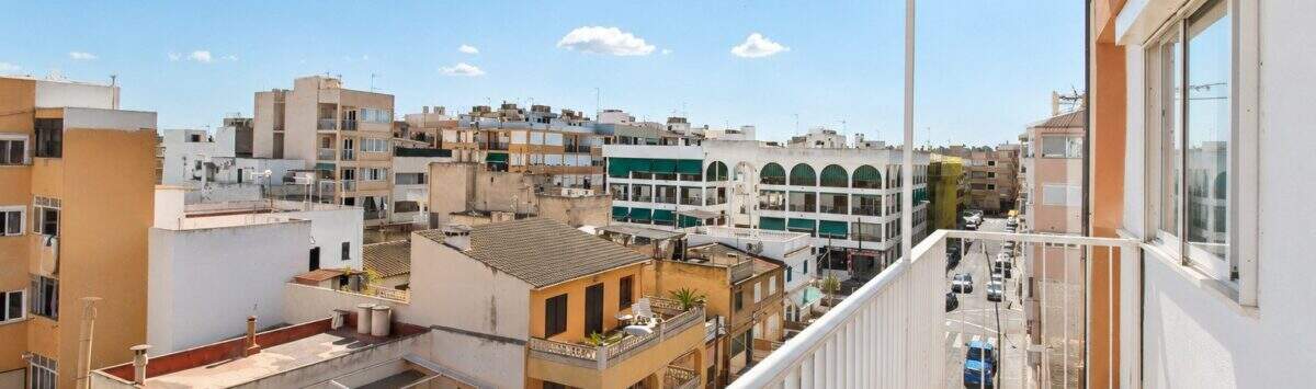 Sonniger Balkon des Penthouses mit Blick über die Dächer von Palma de Mallorca und blauem Himmel.