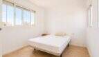 Helles Schlafzimmer im Penthouse Palma de Mallorca mit Doppelbett, weißen Wänden und großen Fenstern.